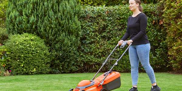 A woman mowing a lawn using a Flymo® wheeled lawnmower.